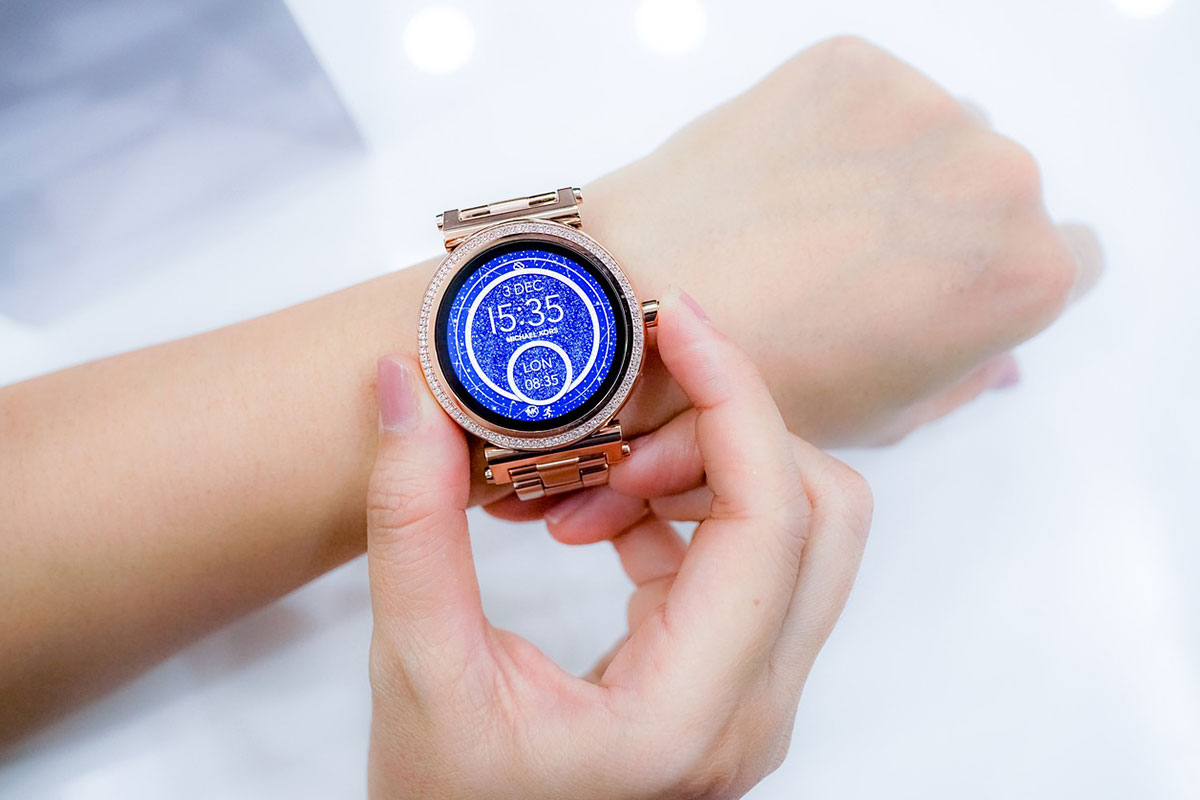 woman wearing a smart watch adjusting it on her wrist