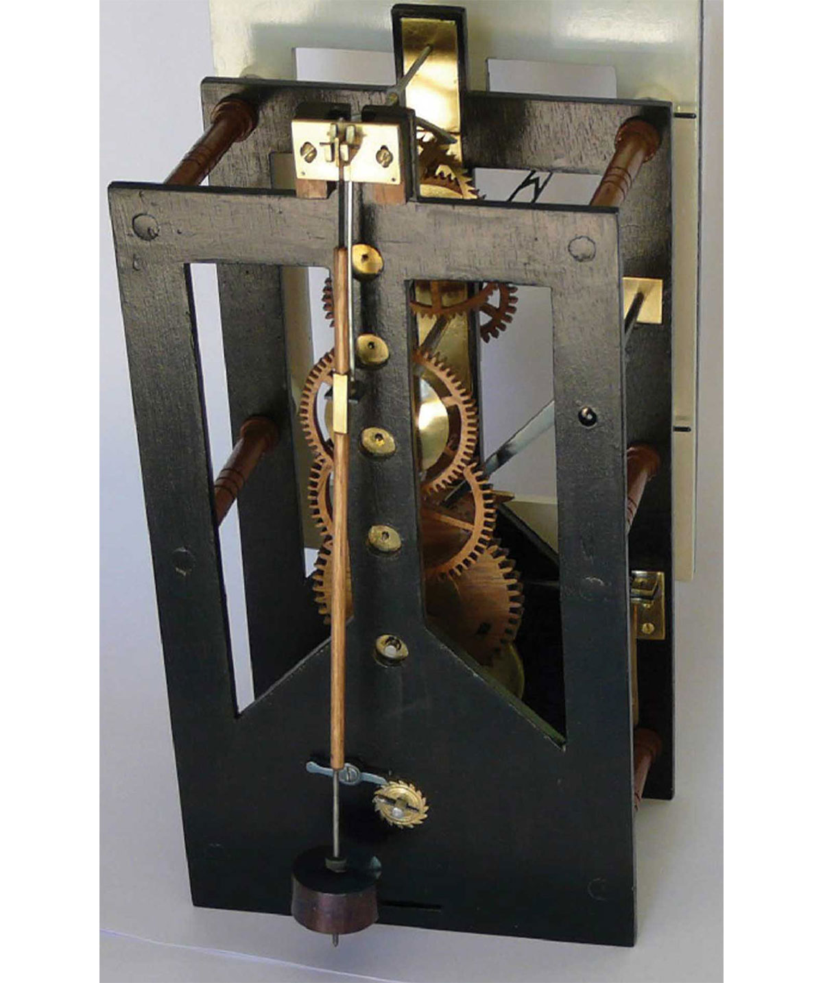 A black painted finished clock case with pendulum and gears exposed