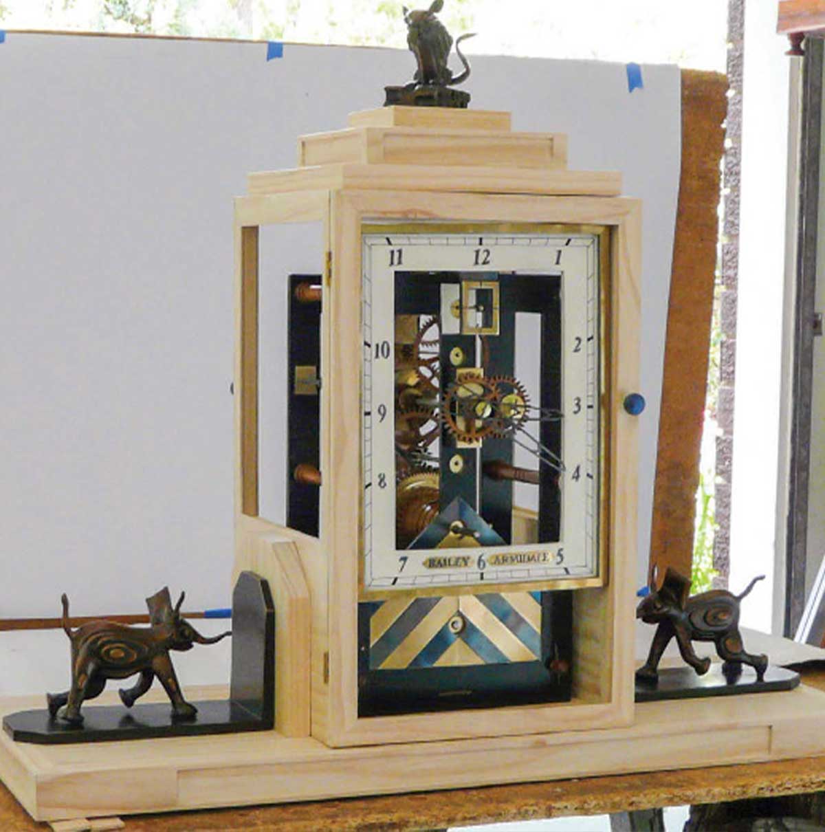 Pine clock case before finishing adorned with finished elephants and mouse