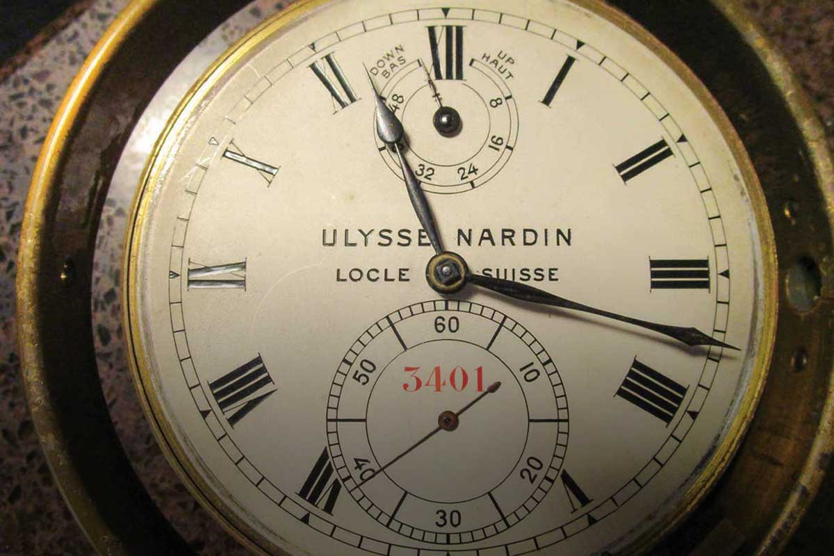 A marine chronometer in its wooden case and gimble