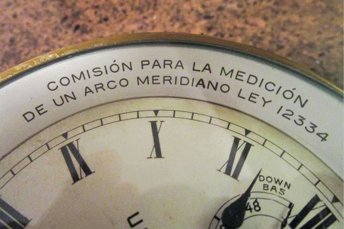 Close-up of dial bezel with the inscription in Spanish: “COMISIÓN PARA LA MEDICIÓN DE UN ARCO MERIDIANO LEY 12334”. Translated into English: “COMMISSION FOR THE MEASUREMENT OF A MERIDIAN ARC LAW 12334