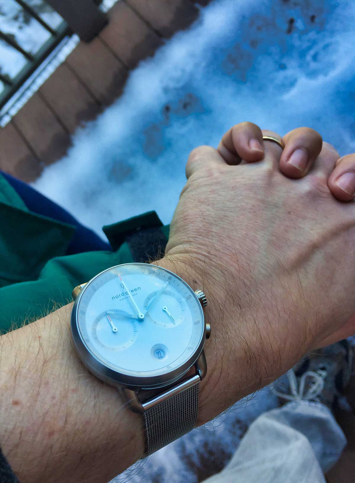 Holding hands of a man an woman with a Nordgreen Pioneer chronograph on the man's wrist