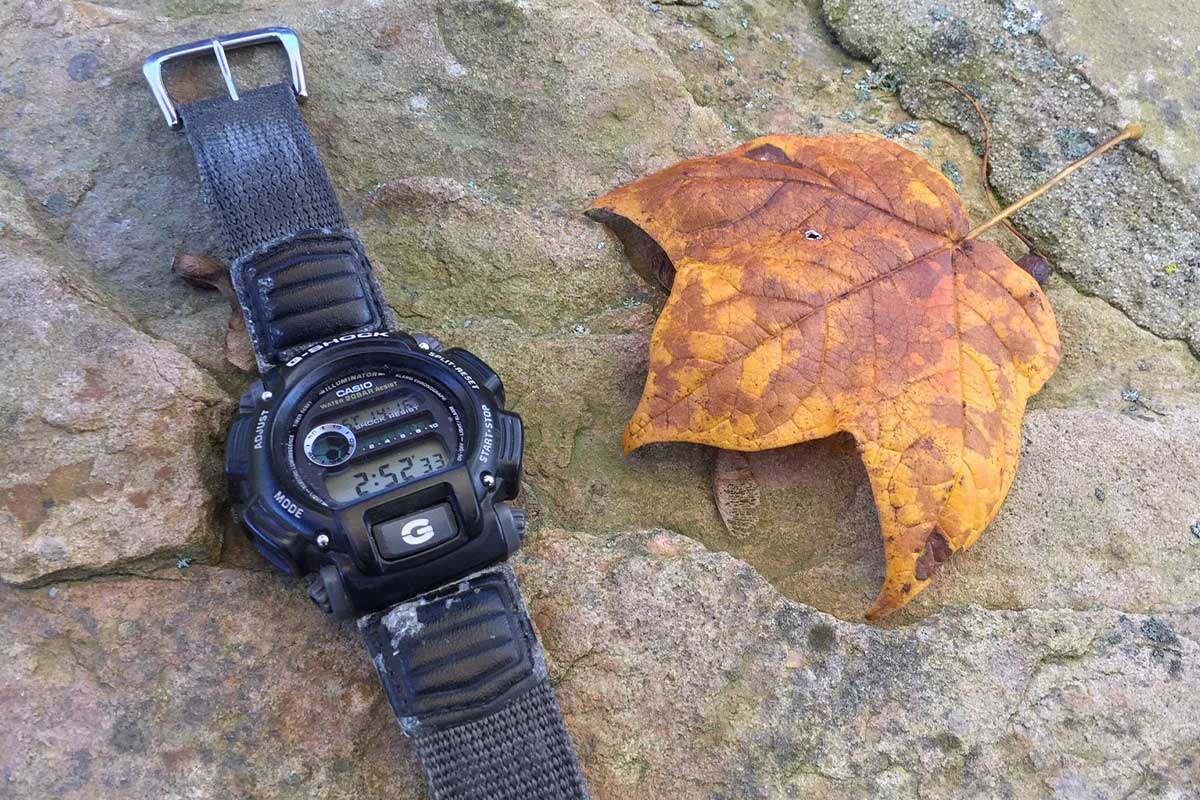 DW-9052V Casio G-Shock beside a leaf on stony ground